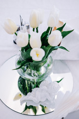 Fresh white tulip flowers in transparent vase