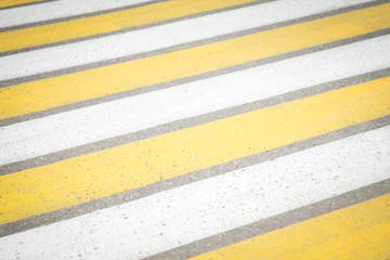 pedestrian crossing yellow and white stripes. diagonal