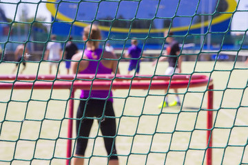 Playing football on the open air. View from behind the gate. Behind the gate