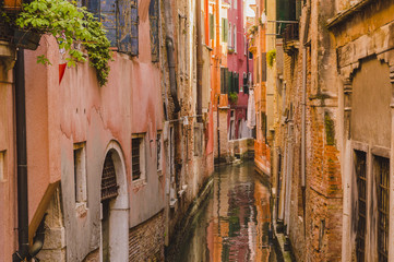Fototapeta na wymiar Old Houses Along Narrow Canal in Venice, Italy