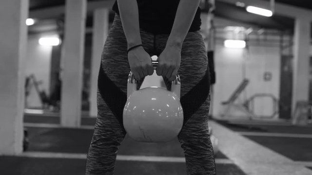 Athletic Woman Exercising With Kettle Bell While Being In Squat Position..