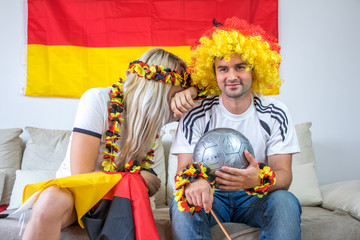Obraz na płótnie Canvas Weiblicher und männlicher Fan der deutschen Nationalmannschaft auf Couch deprimiert
