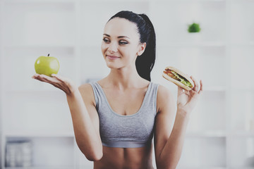 Young woman with apple and hot dog