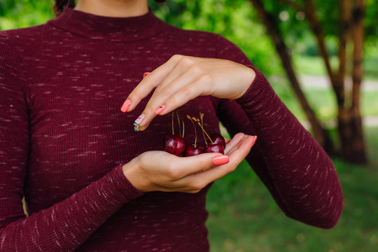Woman holding fresh juicy cherry berries