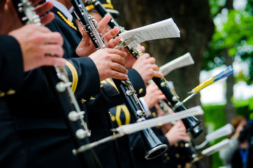 Many unrecognizable orchestra musicians playing musical instruments outdoors. Concept of a musical event