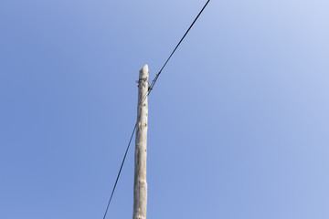 NaZARE, PORTUGAL - Electricity poles and lines against a blue sky