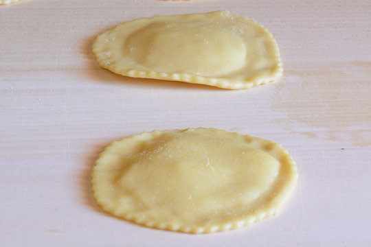 Delicious of Sardinia.Seadas/ typical sardinian sweet, resting on a wooden table before frying