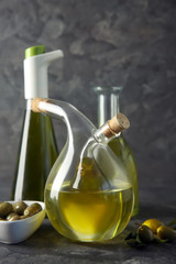 Glassware with oil and olives on table