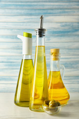 Glassware with oil and olives on wooden table