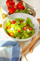 Bowl with fresh vegetable salad on table