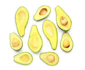 Halves of ripe avocados on white background