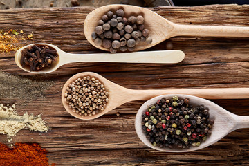 Row of wooden spoons with spices on vintage background, diminishing perspective, close-up, selective focus