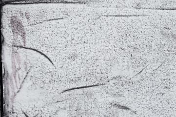 Grunge white felt texture background with black dust spraying, wrinkles and torn edges. Dirty damaged style, worn surface for design or web projects. Space for text. 