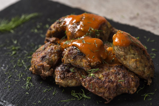Romanian traditional food "chiftele" or "parjoale" with tomato sauce