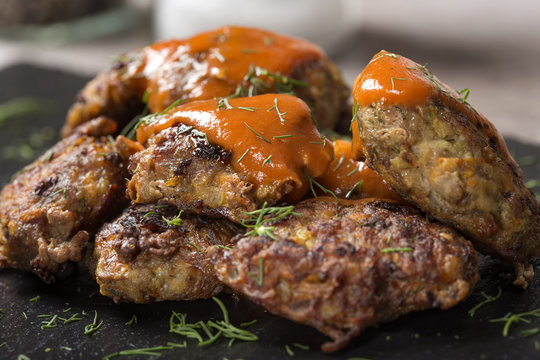Romanian traditional food "chiftele" or "parjoale" with tomato sauce
