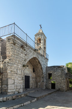 The fasade with the belfry of the functioning church of the Christian Maronites in the abandoned village Kafr Birim in the north of Israel