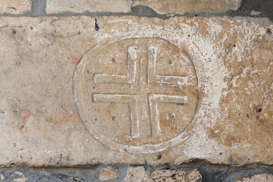 A cross carved on a stone wall on the facade of a church of the Christian Maronites in the abandoned village Kafr Birim in the north of Israel
