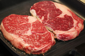 Raw steaks cooked on the pan
