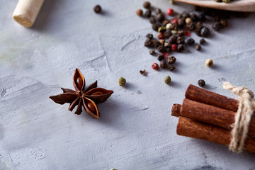 Spices scattered over white textured background, top view, close-up, selective focus.