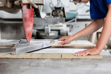 Stone mason woman measuring stone plate for sawing in workshop