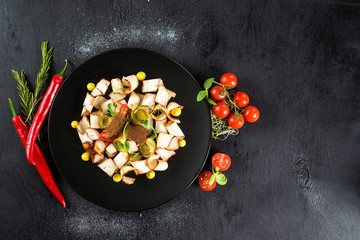 Obraz na płótnie Canvas dish of many pieces of lard with vegetables on black background