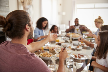 Two Families Enjoying Meal At Home Together