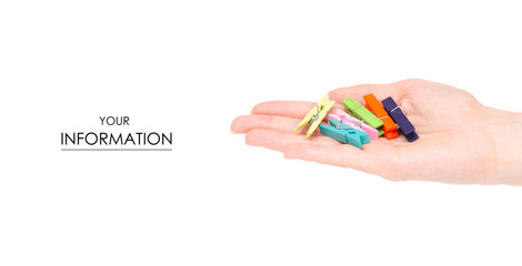 The colorful stationery clothespins in hand pattern on white background isolation