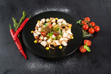 dish of many pieces of lard with vegetables on black background