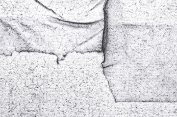 Grunge white felt texture background with black dust spraying, wrinkles and torn edges. Dirty damaged style, worn surface for design or web projects. Space for text. 