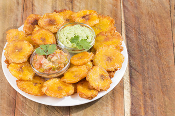 Patacones or tostones are fried green plantain slices, made with green plantains