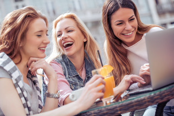 Three happy young woman chatting in cafe