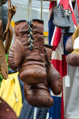 Fototapeta na wymiar An old leather boxing gloves hangs on a market stall.