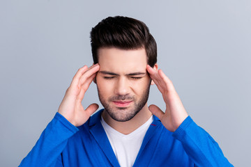 Portrait of stylish guy touching his temples with close eyes trying to remember important...