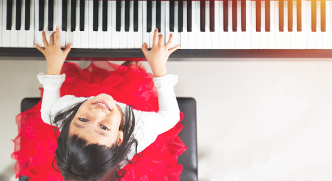 Little asian girl happy to play piano