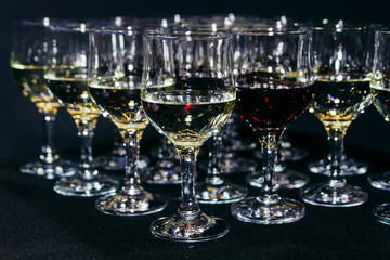 Many glasses of different wine on black bar counter
