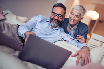 Senior couple with laptop at home