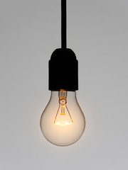 Light bulb shining on gray background