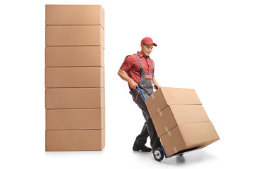 Mover with a hand truck next to a stack of boxes