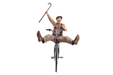 Overjoyed senior with a cane riding a bicycle