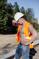 Muscular guy in a construction helmet