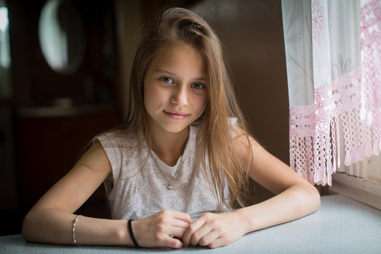 Portrait of cute little girl sitting at the table.