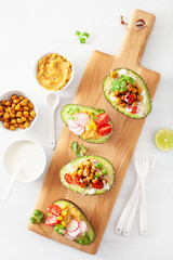 avocado boats stuffed with hummus, tomatoes, radish, roasted chickpea