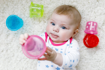Cute adorable newborn baby playing with colorful educational rattle toy