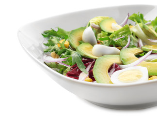 Tasty salad with ripe avocado on plate against white background, closeup