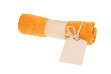 Orange soft towel rolled up and tag paper on white background.