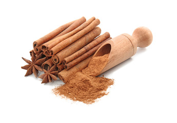 Scoop with cinnamon powder and sticks on white background