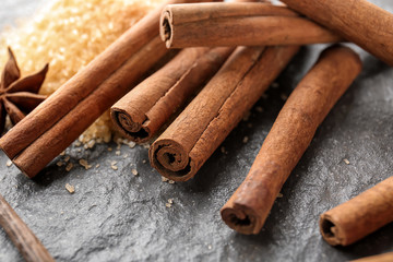 Heap of cinnamon sticks on grey background, closeup