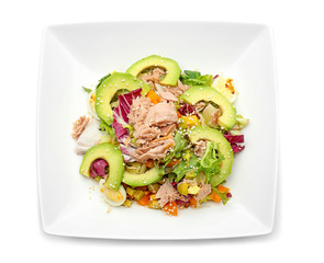 Plate of tasty salad with ripe avocado on white background