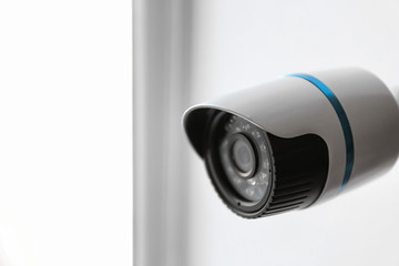 Modern CCTV camera on blurred background, closeup