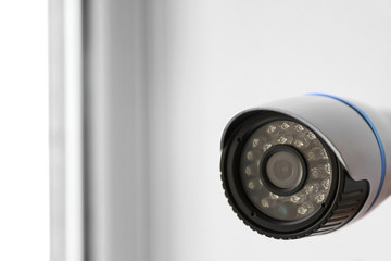 Modern CCTV camera on blurred background, closeup